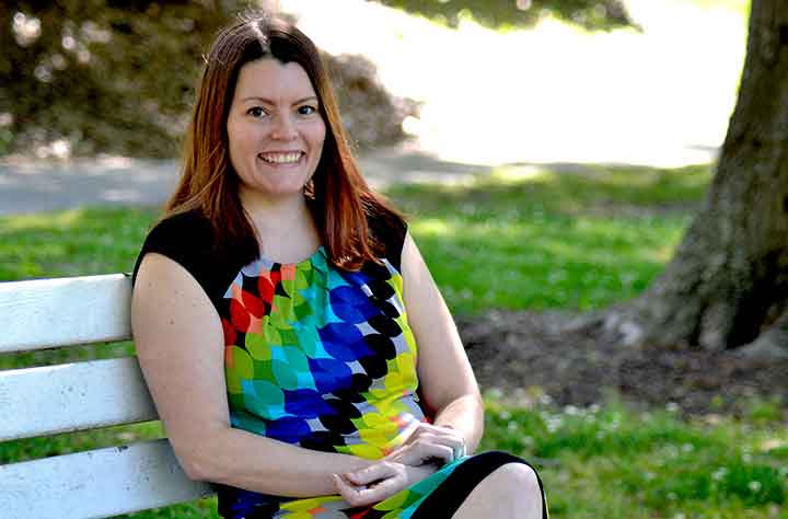 Brooke Bennett-Day sitting on bench in the college quad