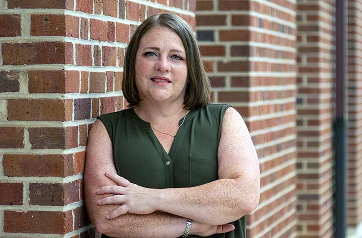 Visit Coordinator Mary Ann Steinbach sits on bench behind Huckabee