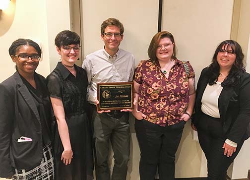 Professor Ferrari holding award and 4 students