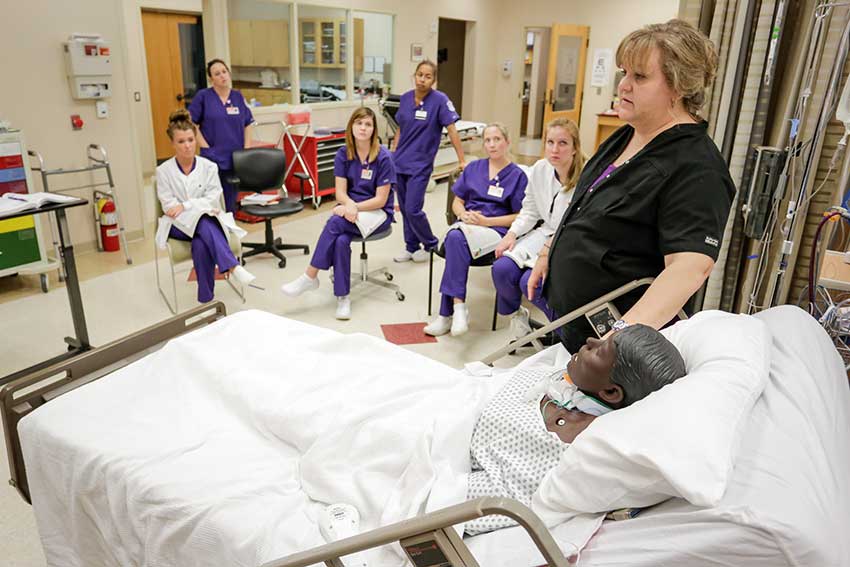 Students listing in Nursing lab as teacher talks.