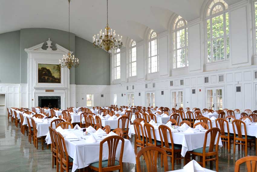 Wesleyan Dining hall with chandeliers, table clothes and napkins set up