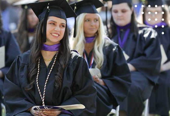 Students sitting in graduate gowns