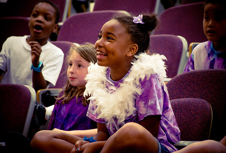 kids college camper smiles with boa.