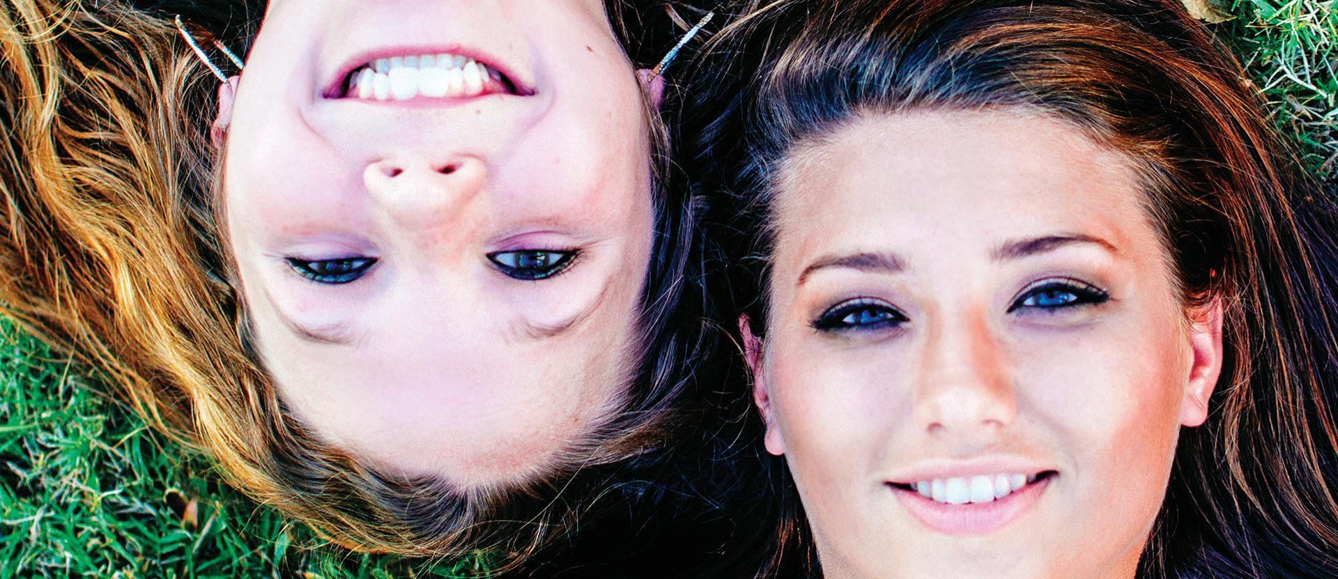 Students laying on the grass looking up at the sky