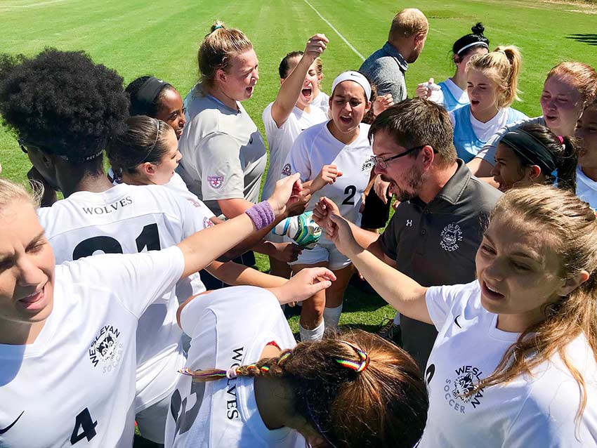 Soccer team huddles during game.