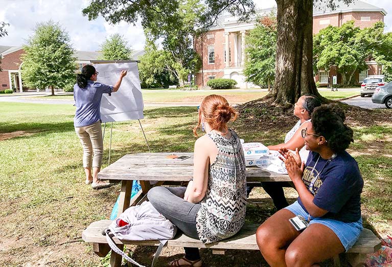 Students studying outside on the picnic table.